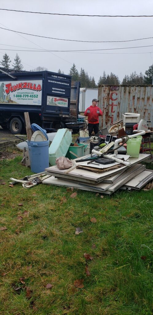 Man standing with waste removal service surrounded by junk and debris